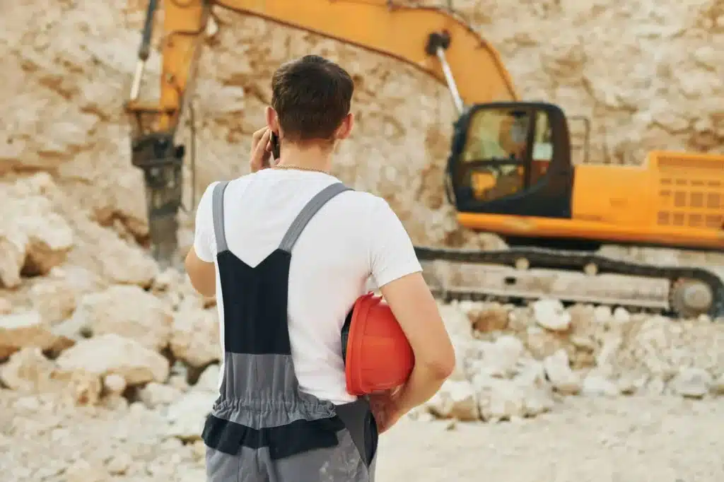 Travaux de terrassement réalisés avec une pelleteuse sur chantier.
